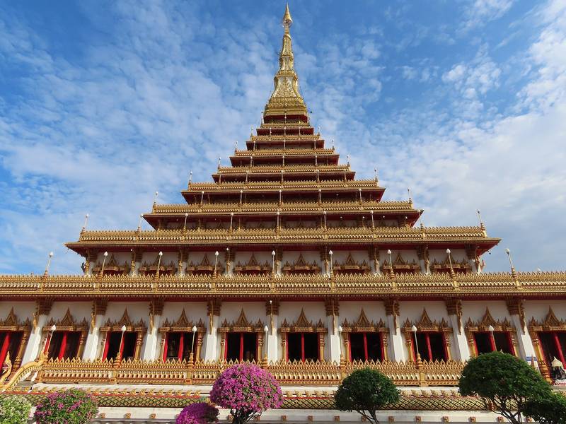 พระธาตุเก้าชั้นสีขาวทองยอดแหลม ใต้ท้องฟ้าสีฟ้ามีเมฆ